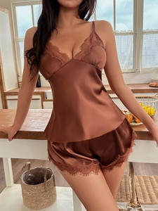 Détail de la dentelle délicate sur le décolleté d'un ensemble de pyjama en satin brun