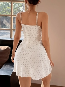 Dettaglio del retro di un abito estivo bianco floreale con pizzo e piccolo fiocco