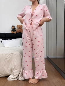 Detail of pink striped pajama set with red heart prints and ruffle trim hem on pants