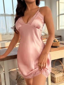 Detailed close-up of pink satin nightgown with V-neckline and intricate lace trim detailing