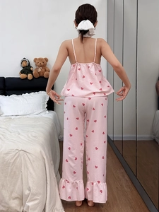 Detail of pink striped pajamas with red hearts featuring camisole top and ruffled hem pants