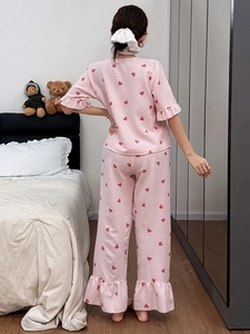 Back view of pink striped pajama set with red heart print and ruffled hem details