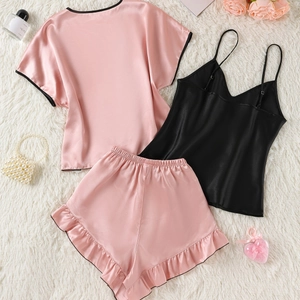 Three-piece satin pajama set with pink top, ruffled shorts, and black camisole cami