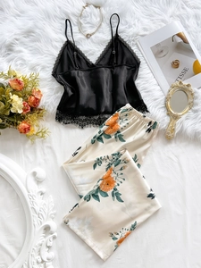 Detail of satin pajama set with black lace camisole and floral print trousers