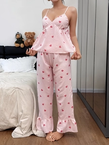 Detail of pink striped pajama bottoms with red hearts and ruffled hem edge
