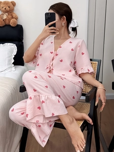 Cozy pink and white striped pajama set with ruffled sleeves and heart prints in a bedroom set