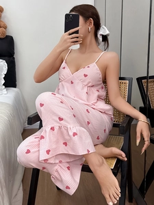 Close-up of pink striped pajamas set with red heart patterns and ruffled hem detail