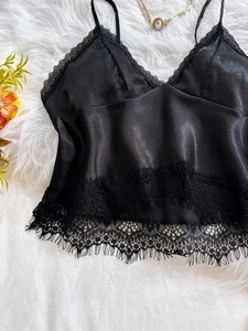 Detail of black satin camisole with delicate eyelash lace trim and silk-like sheen