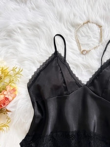 Detail of black satin camisole with delicate lace trim and elegant V-neck design