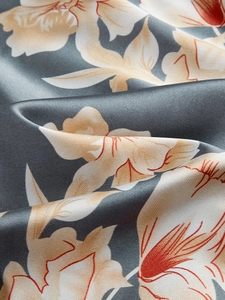 Gros plan détaillé du tissu satiné du pyjama avec motifs de lys et texture soyeuse