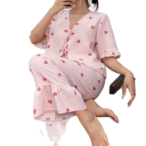 Women's pajama set featuring pink stripes and red heart patterns with ruffle trim details