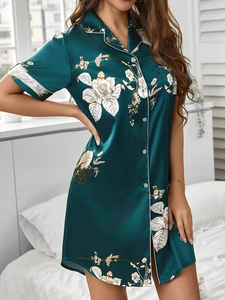 Gros plan sur la chemise de nuit en satin vert émeraude avec imprimé fleurs et oiseaux
