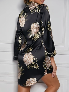 Dettaglio della camicia da notte in raso nero con motivi floreali bianchi e bordini raffinati