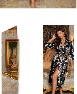 Detail eines Satin-Bademantels mit rosa Blüten auf schwarzem Seidenstoff mit Gürtel