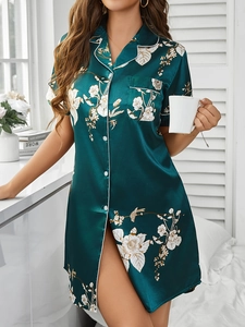 Détail de chemise de nuit en satin vert foncé à fleurs avec revers et passepoil blanc