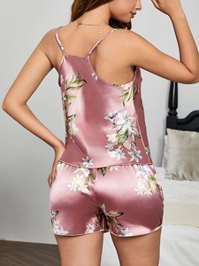 Detail of floral print satin camisole sleepwear set in dusty rose on a model in bedroom
