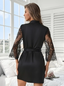 Detail of elegant black satin robe with intricate lace sleeves and belted waist design