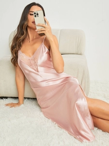 Gros plan sur la robe de nuit en satin rose avec dentelle délicate et fente latérale