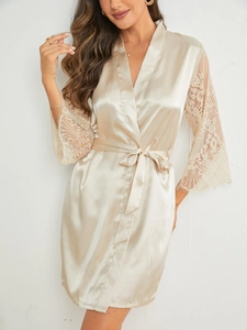 Detail of champagne satin nightgown featuring floral lace sleeves and waist tie