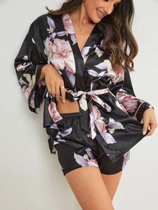 Gros plan détaillé du motif floral sur cet ensemble de pyjama en satin noir
