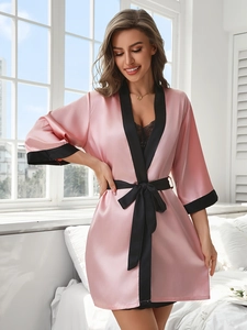 Détail du peignoir en satin rose avec bordure noire et ensemble de lingerie en dentelle