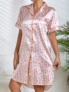 Détail d'une chemise de nuit satinée à rayures roses avec cœurs dorés et col à revers