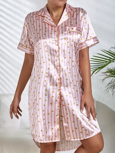 Détail d'un pyjama en soie à rayures roses avec motifs de cœurs et col à revers chic