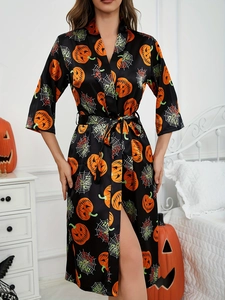 Detail of satin Halloween robe with orange pumpkin and white spider web prints