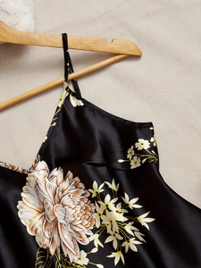Detail of black silk satin camisole with large white chrysanthemum print and thin straps