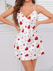 Detailed view of white satin slip nightdress with red hearts and ruffled hemline