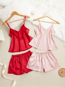 Détail d'un pyjama en satin rouge et rose avec bordure en dentelle délicate