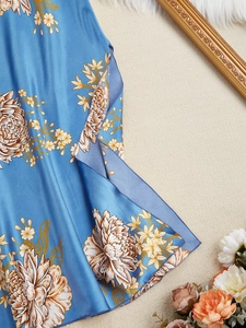 Détail du tissu en satin bleu de la nuisette avec imprimés de chrysanthèmes blancs