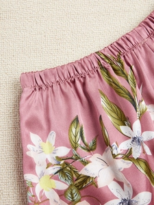 Détail de pyjama en soie rose à motif floral avec taille élastique et tissu satiné doux