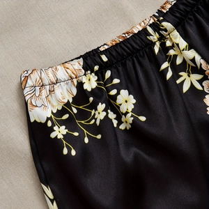 Women's black floral satin pajama set with elastic waistband and smooth silk texture