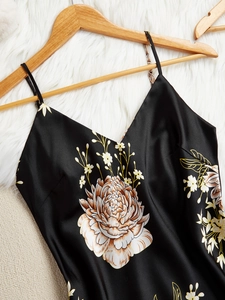 Détail de chemise de nuit en satin noir à fleurs avec bretelles sur cintre