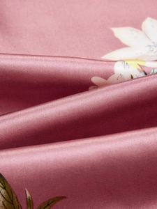 Détail macro du tissu en soie glacée rose poudré avec imprimé floral et fini satiné