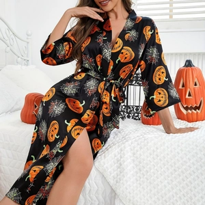 Women Halloween satin robe with pumpkin and spider web prints in a festive home setting