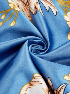Détail du tissu en satin bleu soyeux avec imprimé floral pour nuisette de luxe