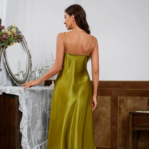Elegant olive green satin slip dress with thin straps shown in a vintage home interior