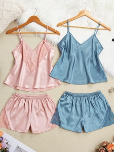 Vue détaillée des pyjamas en satin avec dentelle en rose et bleu sur cintres