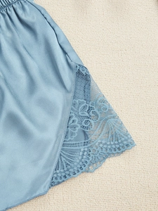Détail du short de pyjama en soie bleu clair avec dentelle florale délicate au bord