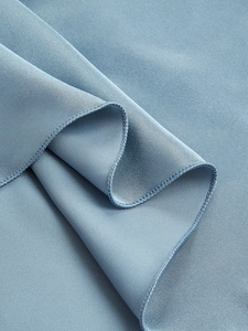 Gros plan détaillé du tissu en soie glacée bleu ciel avec coutures surjetées de qualité