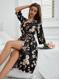 Détail du peignoir kimono en satin avec des fleurs rouges sur tissu en soie noire