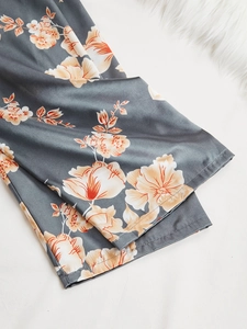 Detail of satin floral sleepwear pants showing smooth silk texture and hem stitching
