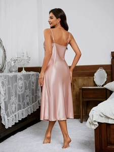 Détail d'une nuisette en satin rose poudré avec bretelles croisées et texture soie lisse