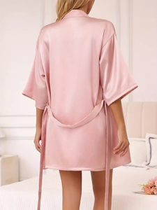 Vue arrière d'un peignoir en satin rose montrant la texture soyeuse et le lien de taille