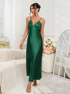 Close-up of deep green satin nightdress featuring delicate lace trim on the V-neckline