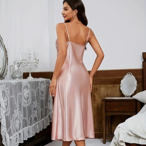 Nuisette élégante en satin rose avec fines bretelles et coupe trapèze dans une chambre