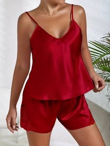 Détail de l'ensemble pyjama en satin rouge avec dentelle délicate sur le côté du short