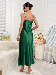 Detail of dark green satin nightgown with thin straps and glossy silk-like texture